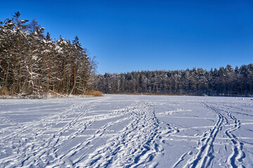 Fototapeta na wymiar Steps on the lake ice covered with snow 