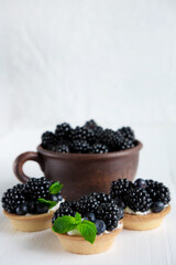 Fototapeta na wymiar Fresh blackberries. Homemade tortillas with blackberries. Summer desserts with berries that are good for your health. Vertical photo with bramble and place for an inscription