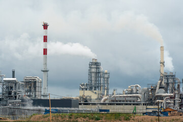Factory chimneys against the gray autumn sky. Utopian landscape background. White toxic smoke is coming from a huge pipe. Pollution of the environment and nature. The collapse of civilization.
