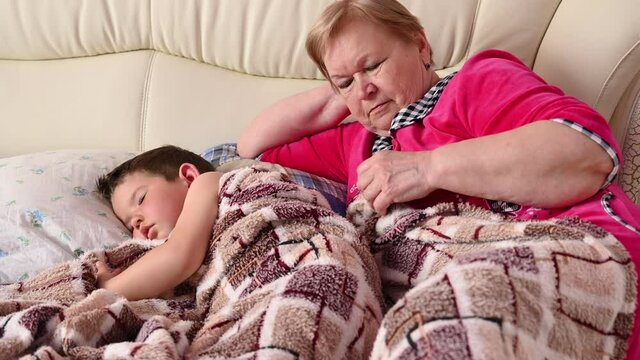 Grandmother puts the child to bed 