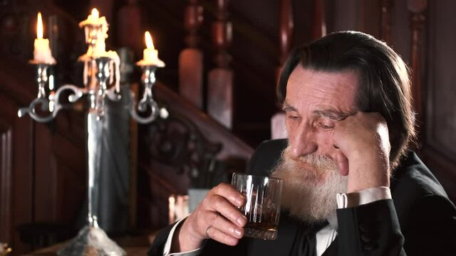 Senior stylish man drinking alcohol in pub