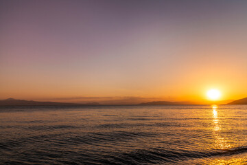 Beautiful sunset on the lake with mountains. Summer landscape.