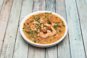 Shrimp ceviche with a lot of product and a lot of juice with parsley and red onion