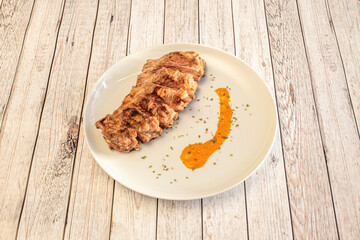 Roasted pork rib with carrot sauce and oregano