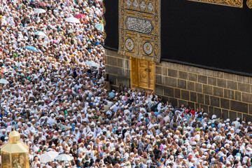 Holy Kaaba in Mecca city. Door of Kaaba - Multazam. Crowd of muslim pilgrims circumambulate (tawaf)