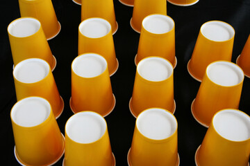 disposable paper cups on black background. Set of yellow empty paper coffee cups
