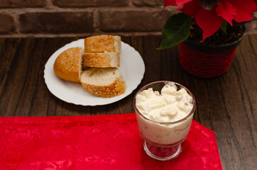 Apple salad with cream. Bowl with apple salad on wooden table with poinsettia.