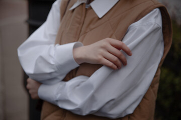 Woman in white shirt cross the hands. Woman hands close up.