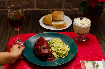 Roasted ribs marinated with barbecue sauce served with mashed potatoes, spaghetti and bread. Plate of food served on wooden table