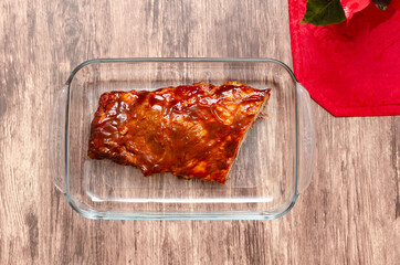 Ribs prepared in the oven with barbecue sauce. Roasted ribs served on plate on wooden table.
