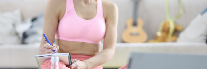 Woman makes home workout plan in diary