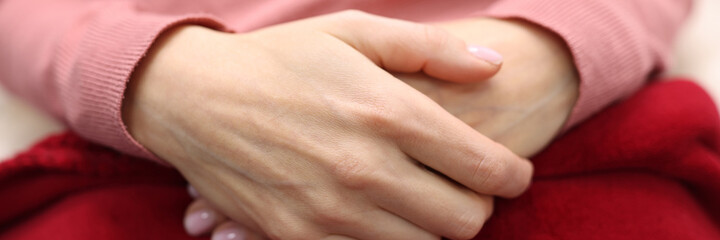 Women's hands are folded together. Feminine serenity and self-confidence