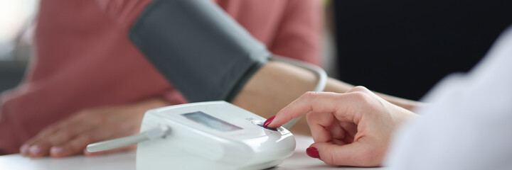 Doctor measures the patient's blood pressure closeup