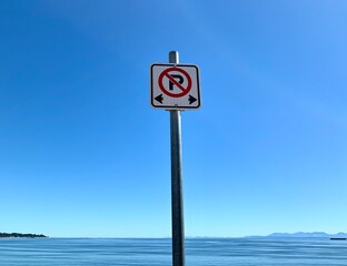 No Parking sign on the beach, clear blue sky background