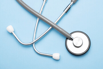 Grey stethoscope on blue background. Medical concept