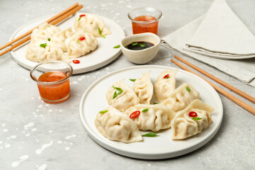 Jiaozi gyoza dumplings steamed on white plates with soy sauce and chili sauce. Food takeaway, home delivery
