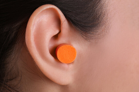 Young woman with  foam ear plug, closeup view