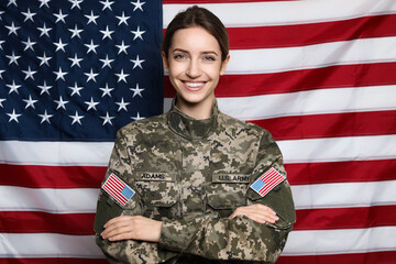 Portrait of happy female cadet against American flag - obrazy, fototapety, plakaty