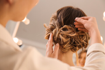 Fototapeta premium Stylist working with client in salon, making hairstyle