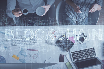 Double exposure of man and woman working together and crypto theme hologram drawing. Computer background. Blockchain concept. Top View.
