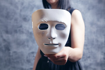 woman holding white plastic mask