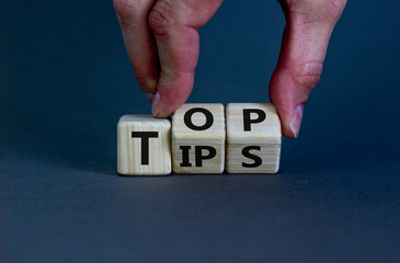 Top tips symbol. Businessman turns wooden cubes with words 'Top tips'. Beautiful grey background. Top tips and business concept. Copy space.