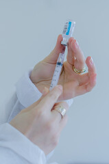 nurse's hands snorting a dose of coronavirus vaccine