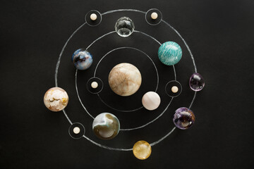 Crystal stones set in the form of a planetary system on black background. Round gemstones as planets on dark background