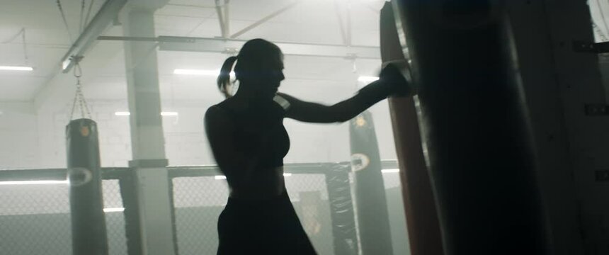 HANDHELD WIDE to CU Caucasian female boxer practicing punches in the boxing gym. Shot with 2x anamorphic lens