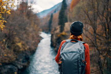 woman hiker backpack river travel to the mountains
