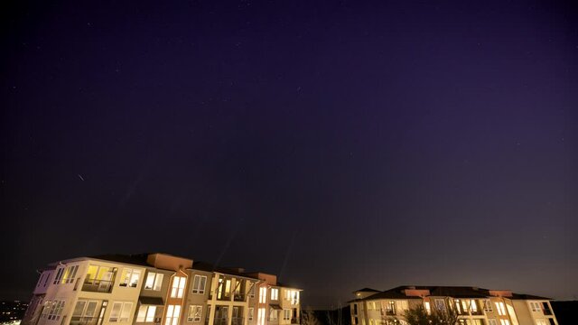 Apartment Complex Clear Stars Timelapse. a timelapse of the night sky stars circling around the north star over some apartment buildings