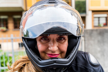 portrait of mature woman with motorcycle helmet outdoors