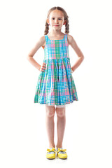 Cute european little girl in colorful dress with pigtails isolated on white background.