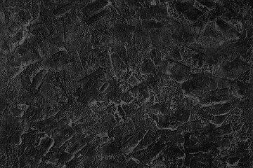 Fototapeta na wymiar Abstract dark grey plastered textured grunge background in the form of a rough covered stucco wall, closeup