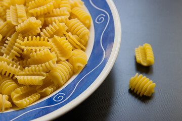 Closeup of a plate with raw radiatori, an Italian pasta