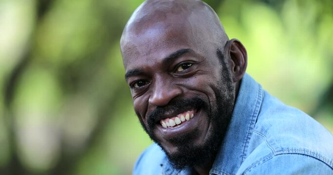 African man smiling portrait outside at park