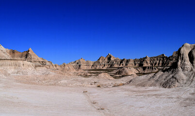 Badlands National Park showing valleys and mountains with a dark blue sky in the background. 