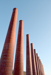 Rows of brick smoke stacks against a blue sky background.