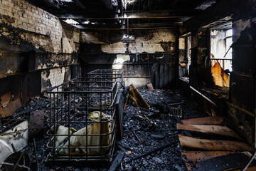 Burnt out shop after fire with charred walls and remains of furniture