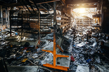 Burnt out shop after fire with charred walls and remains of furniture