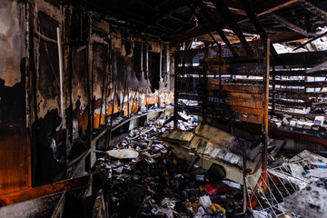 Burnt out shop after fire with charred walls and remains of furniture