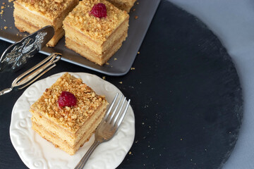 Homemade honey cake on slate background. Honeycomb with raspberry. Dark background. Selective focus.