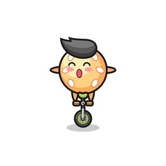 The cute sesame ball character is riding a circus bike