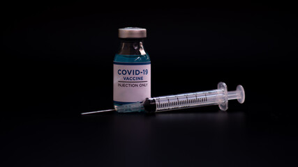 accine for vaccination against covid-19, vaccine bottle, syringe, mask, on black background, copy space, web banner.