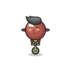 The cute chocolate ball character is riding a circus bike