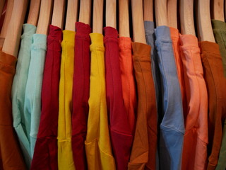 clothes hanging on a railing in a clothing store. 