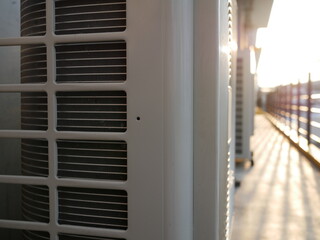 air conditioner compressor outside building with sunlight.