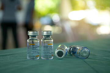 Close-up of empty Glass medicine or vaccine bottles with injection fluid with white aluminium caps. Narrow depth of field. Corona Covid-19 vaccine