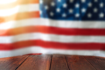 Empty wooden table in front of the blurred American flag. Independence day concept