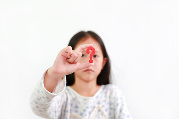 Asian little child girl holding red question mark sign over white background. Selective focus